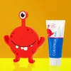 A red cartoon monster toy and a tube of Curaprox kids toothpaste are displayed against a bright yellow background. Anteprima dell’immagine prodotto