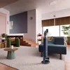 A modern living room with a blue cordless vacuum cleaner standing on a rug. Podgląd zdjęcia produktu