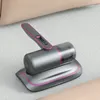 A handheld vacuum cleaner with a charging base, placed on a textured surface. Produktbild-Vorschau