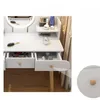 A close-up view of a white vanity table with drawers and makeup items. Podgląd zdjęcia produktu