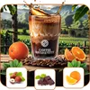 A coffee drink with coffee beans, oranges, hazelnuts, and chocolate in a natural setting with mountains and fields in the background. Náhled obrázku produktu
