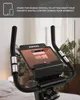 Close-up of a stationary exercise bike's handlebars and tablet stand, with a tablet displaying a music app. Produktbild-Vorschau