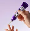 A hand holding a tube of eye cream and dispensing a small amount onto a finger. Voir les images du produit