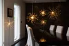 A dining room with starburst LED lights hanging above a table. Produktbild-Vorschau