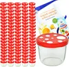 A stack of glass jars with red and white mushroom-shaped lids, along with a recipe booklet and a packet of jelly powder. Produktbild-Vorschau