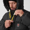 A man is adjusting the hood of a black puffer jacket. Produktbild-Vorschau