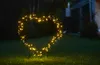 A heart-shaped light decoration with yellow LEDs is placed on a lawn at night. Produktbild-Vorschau