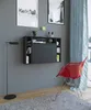 A wall-mounted desk with shelves and a red chair in a room with a window and artwork on the wall. Podgląd zdjęcia produktu