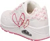 A side view of a white sneaker with pink heart designs. Voir les images du produit