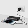 A black power bank is charging a smartphone, and the power bank itself is plugged into a wall outlet. Náhľad obrázku produktu