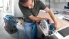 A man is using a circular saw with a vacuum attached to cut a piece of wood. Náhled obrázku produktu