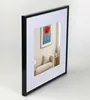 A black picture frame with a white matting, displaying a painting of a red poppy. Produktbild-Vorschau