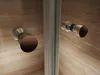 Close-up of shower door handles against a marble-like background. Produktbild-Vorschau