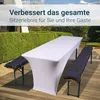 A white table covered with a fitted tablecloth and two dark gray bench cushions on wooden benches, set up on a wooden deck outdoors with a hedge and sky in the background. Produktbild-Vorschau