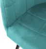 A close-up view of a teal velvet dining chair, showing the quilted texture and stitching. Náhľad obrázku produktu