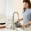 A woman is using a portable carpet cleaner in a kitchen sink. Podgląd zdjęcia produktu