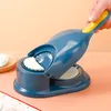 A hand is using a blue and yellow dumpling maker to create a dumpling. Podgląd zdjęcia produktu