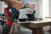 A person is using a cordless circular saw to cut a piece of wood on a workbench. Anteprima dell’immagine prodotto