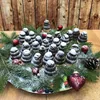 A festive arrangement of Christmas cookies decorated with powdered sugar, surrounded by pine branches and ornaments on a plate. Náhled obrázku produktu