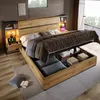 A modern bedroom with a large bed featuring a storage headboard and hydraulic storage. Produktbild-Vorschau