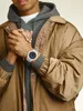 A person wearing a watch and jacket. Produktbild-Vorschau