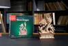 A wooden dragon model kit box and the assembled model are displayed on a dark surface in front of bookshelves. Anteprima dell’immagine prodotto