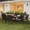 An outdoor patio dining set with chairs and a table, illuminated by string lights. Produktbild-Vorschau