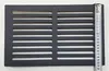 A black metal grate with horizontal slots is placed on a white surface, with a measuring tape on the right side. Voir les images du produit