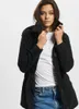 A woman wearing a black jacket and blue jeans. Produktbild-Vorschau