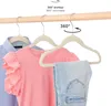 Three children's hangers with clothes hanging on a wooden rod. Produktbild-Vorschau