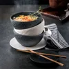 A stack of three textured bowls, one filled with soup, with chopsticks and a napkin nearby. Podgląd zdjęcia produktu