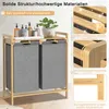 A laundry basket with two compartments and a shelf on top, displayed in a room setting with some toiletries and a plant on the shelf. Close-up shots of the bamboo material and construction are shown on the right side. Náhled obrázku produktu