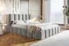 A bedroom scene with a bed as the main focus, set against a wall with decorative panels and a large window with curtains. Náhled obrázku produktu