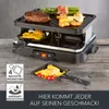 A raclette grill with food being cooked on it, and a small pan with food in the foreground. Produktbild-Vorschau