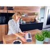 A woman is using a vacuum sealer machine to seal a bag of berries in a modern kitchen. Anteprima dell’immagine prodotto