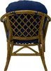 The back view of a rattan armchair with a blue cushion. Produktbild-Vorschau