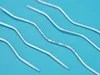 Several curved knitting needles are arranged diagonally on a blue background. Produktbild-Vorschau