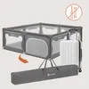 A playpen, a suitcase, and a carrying bag are shown against a light gray background. An orange arrow indicates the playpen is being placed into the carrying bag. Anteprima dell’immagine prodotto