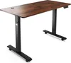 A standing desk with a wooden top and black metal legs, shown from a slightly elevated angle against a white background. Náhled obrázku produktu