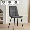 A gray upholstered dining chair with black metal legs, set against a neutral background with decorative wall paneling and a white shelf unit on the left. Three informational icons are displayed at the top. Náhled obrázku produktu