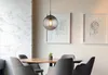 A dining area with a table and chairs, illuminated by a pendant light. Voir les images du produit