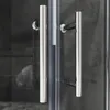A close-up view of two chrome handles on a glass shower door. Voir les images du produit