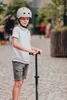 A young boy wearing a helmet and holding a scooter. Náhled obrázku produktu