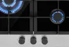 A close-up view of a gas stove top with burners and control knobs. Produktbild-Vorschau