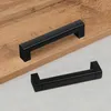 Two black handles are placed on a wooden surface and a gray surface. Podgląd zdjęcia produktu