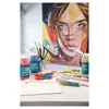An artist's workspace with art supplies and a painting. Náhled obrázku produktu