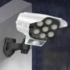 Weiße solarbetriebene Sicherheitsleuchte mit sieben LED-Lampen und einem Bewegungssensor, montiert an einer grauen Wand bei simuliertem Regen Voir les images du produit