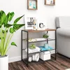 A shelf unit with decorative items and books next to a large potted plant. Produktbild-Vorschau