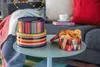 A cozy living room scene with decorative tins and cookies on a coffee table. Produktbild-Vorschau