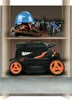 A storage cabinet with tools on the top shelf and a lawnmower on the bottom shelf. Produktbild-Vorschau